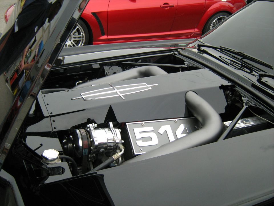 Black engine bay with a Lincoln emblem on a cover, and a license plate reading 514