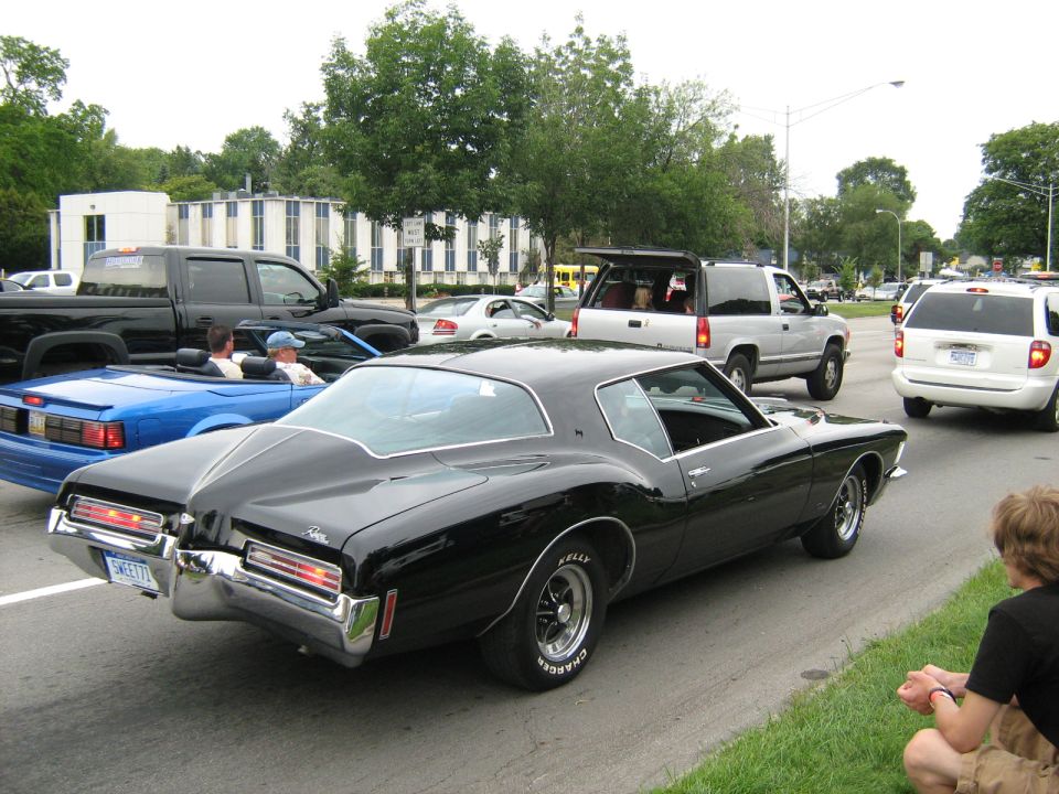 Black 1971 Buick Riviera coupe, rear view. Other cars and people visible