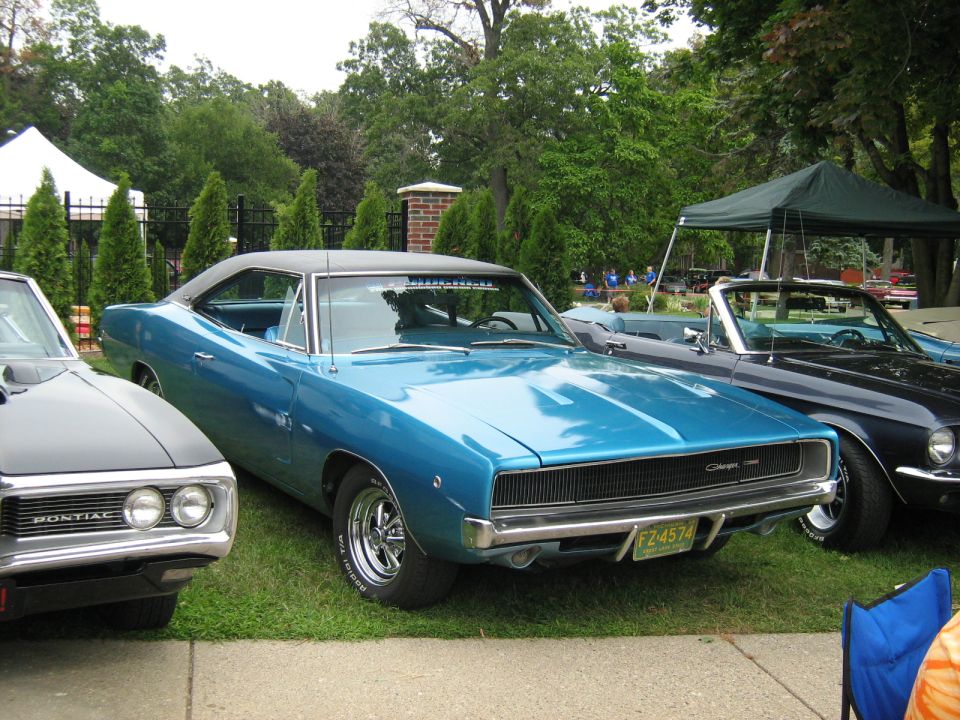 Blue 1968 Dodge Charger with a black vinyl roof and chrome wheels parked on grass