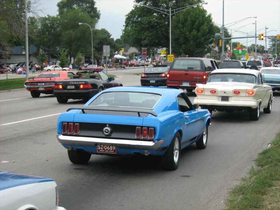 Blue 1969 Mustang with a spoiler and a license plate that reads SZ-0689
