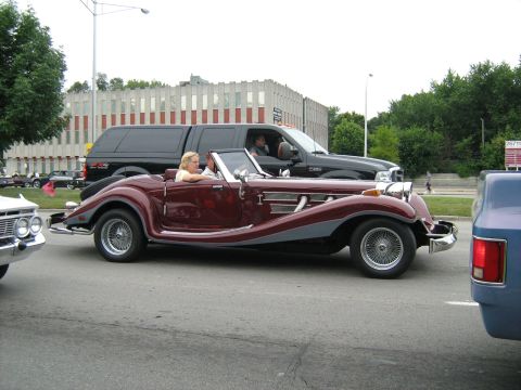 1988 Mercury Grand Marquis - A classic-style convertible is seen driving on a street with other vehicles around it.