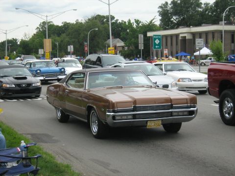 1988 Mercury Grand Marquis - A brown coupe from the 1970s is seen in traffic during a car show.