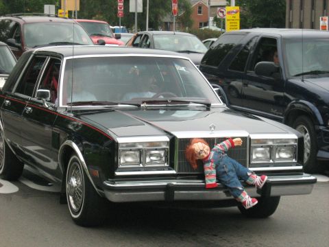 1988 Mercury Grand Marquis - A Chrysler New Yorker from the early 1980s is seen with a doll strapped to its grille.