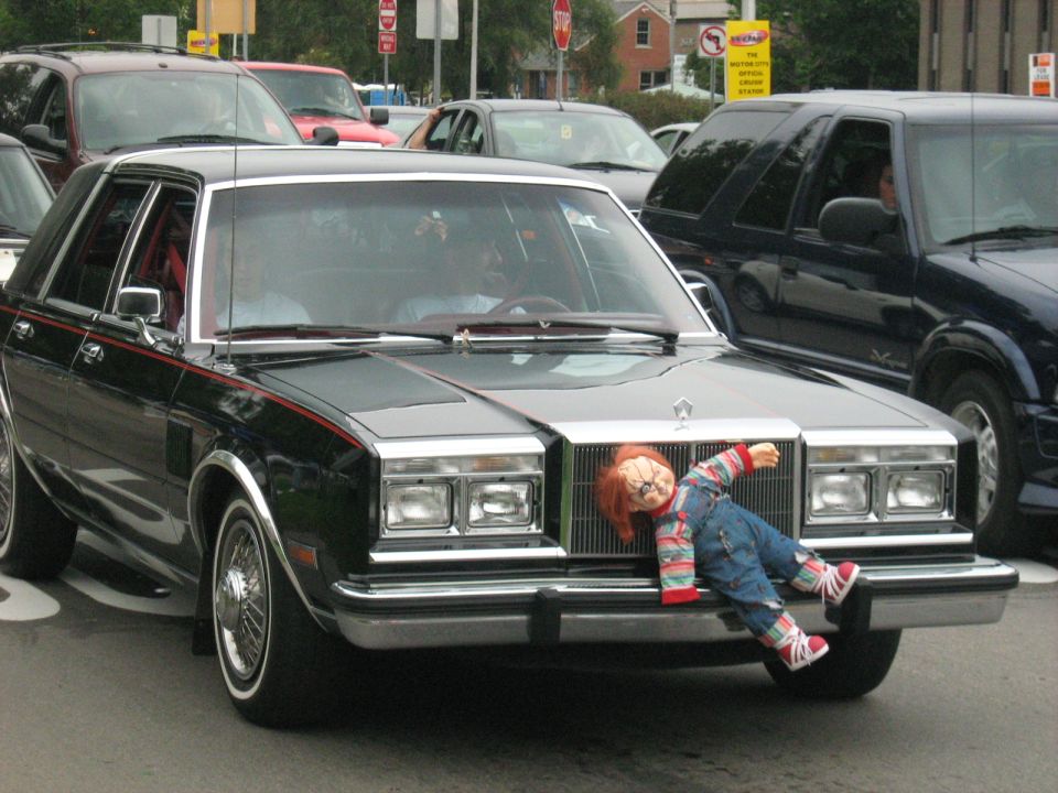 1981 Chrysler New Yorker with a Chucky doll attached to the front grille