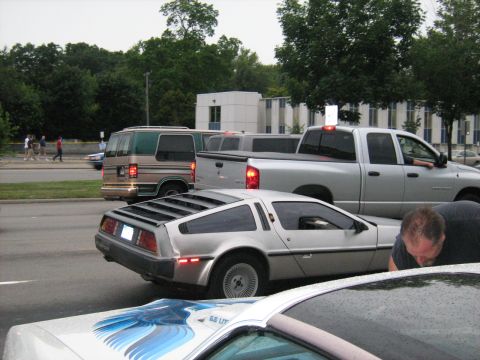 1988 Mercury Grand Marquis - A silver DeLorean DMC-12 is seen from the rear in traffic, alongside other vehicles.