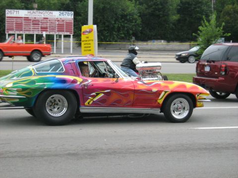 1988 Mercury Grand Marquis - A heavily modified Chevrolet Corvette Stingray with a vibrant paint scheme and a prominent engine is seen on the road.