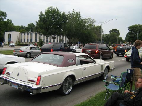 1988 Mercury Grand Marquis - A white 1984 Lincoln Continental Mark VII is parked on the side of the road during a car show.