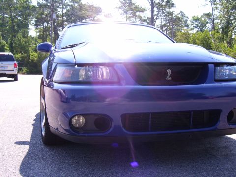 2003 Ford Mustang - Front view of a blue 2003 Ford Mustang Cobra parked outdoors with another vehicle behind it.