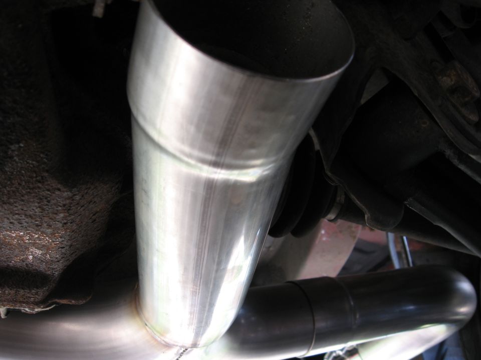 close-up of shiny metal exhaust pipes under a car
