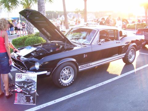 2003 Ford Mustang - A black 1968 Shelby GT500 KR Mustang is displayed with its hood open at a car show.