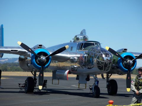 1990 Ford Bronco - A B-25 Mitchell bomber sits on the ground under a bright blue sky.
