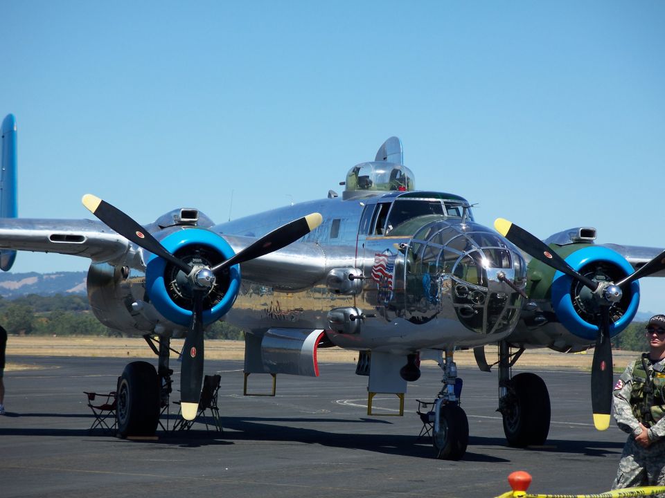 North American B-25 Mitchell bomber parked on tarmac, clear blue sky
