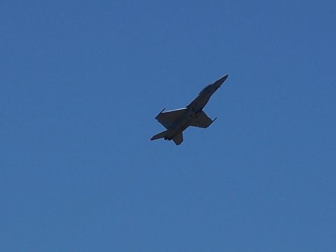 1990 Ford Bronco - A fighter jet is captured in mid-flight against a bright blue sky, with the Supermotors logo visible at the bottom right.