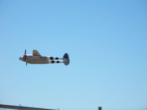 1990 Ford Bronco - A P-38 Lightning aircraft flies with its distinctive twin booms and central fuselage.