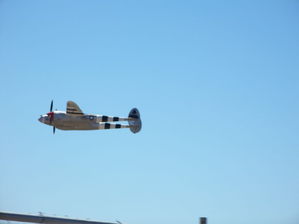 Lockheed P-38 Lightning airplane in flight against a clear blue sky