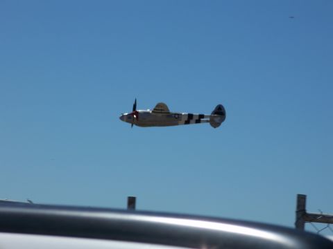 1990 Ford Bronco - A vintage twin-engine aircraft is captured in flight against a bright blue sky.