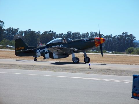 1990 Ford Bronco - An airplane with military markings sits on a tarmac under a clear blue sky.
