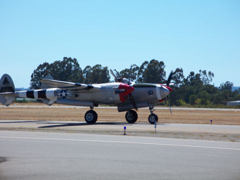 1990 Ford Bronco - A Lockheed P-38 Lightning airplane sits on a runway under a clear blue sky.