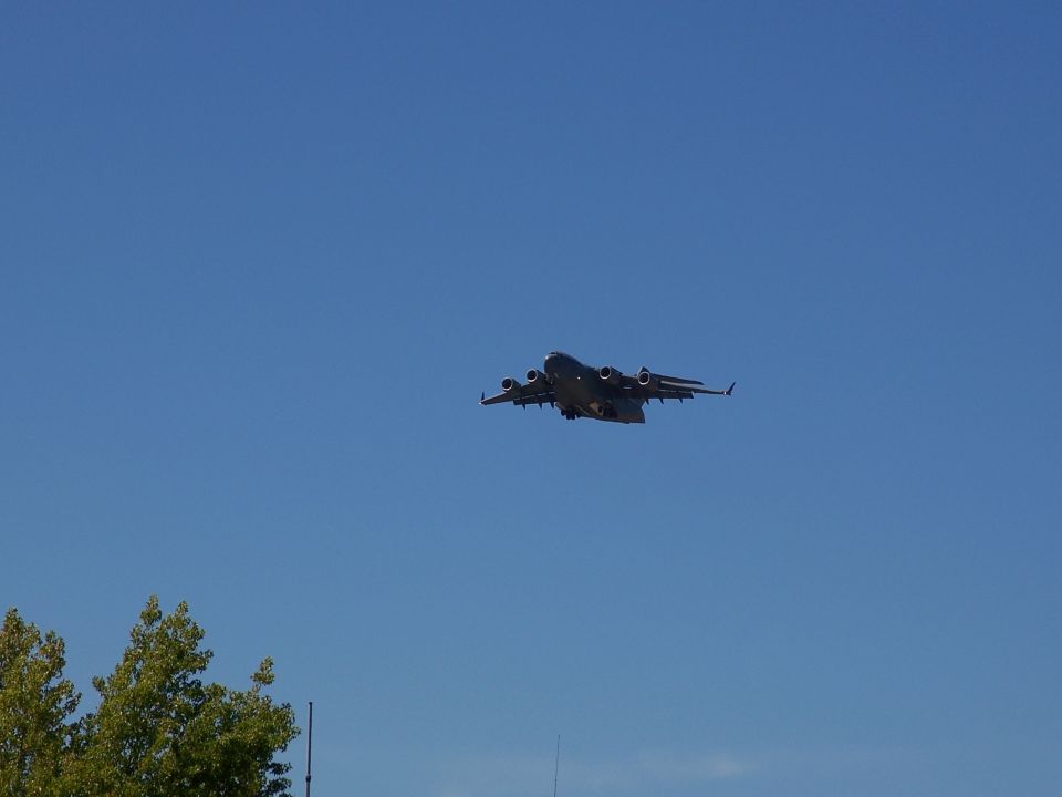 Large military cargo plane flying in a clear blue sky