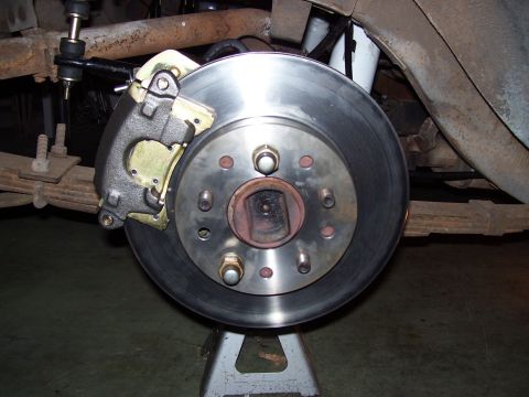 1968 Ford Mustang - Close-up view of a vehicle's brake system, including the rotor, caliper, and suspension parts.