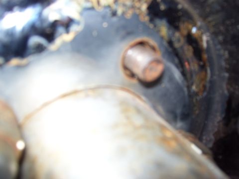 1968 Ford Mustang - Close-up view of a rusty bolt on a dark, textured surface, with a watermark at the bottom right.