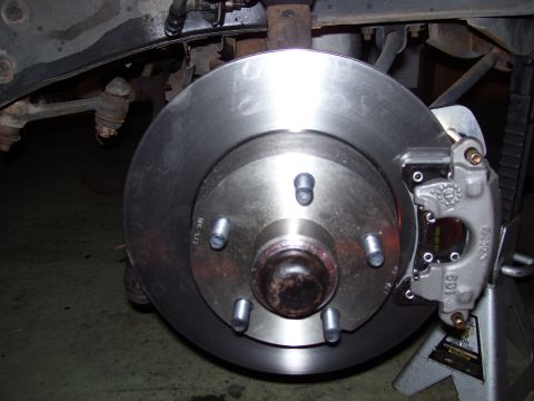 1968 Ford Mustang - Front brake rotor and caliper assembly on a vehicle, likely undergoing maintenance or repair.