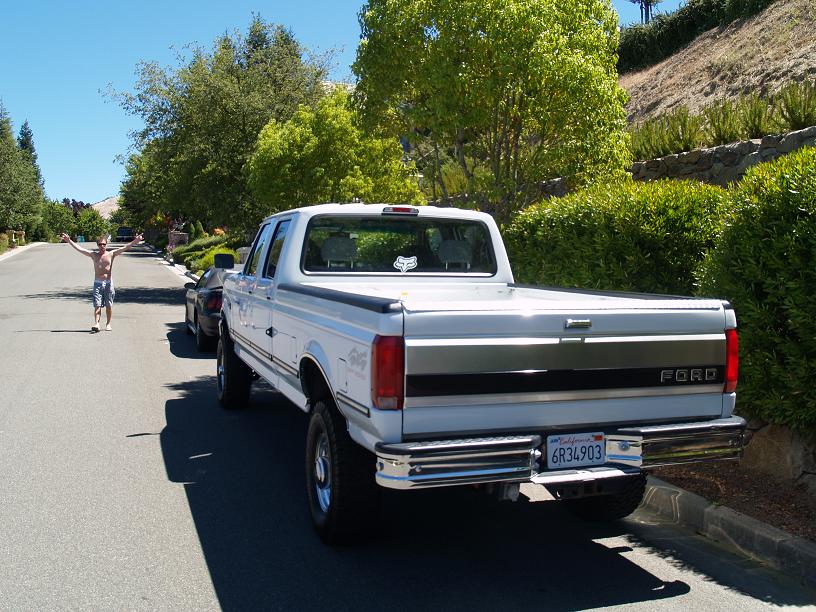 White Ford F-150 pickup truck, rear view, chrome bumper, California license plate 6R34903, parked on street