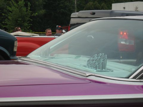 1988 Mercury Grand Marquis - A customized purple car with exposed exhaust pipes is seen at a car show, with other vehicles in the background.