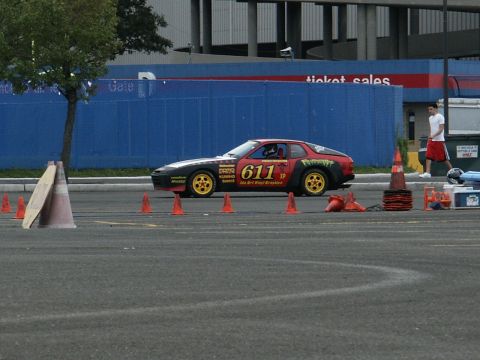 2001 Mercury Grand Marquis - A Porsche 944, number 611, is set up for a race on a paved course with orange cones marking the track.