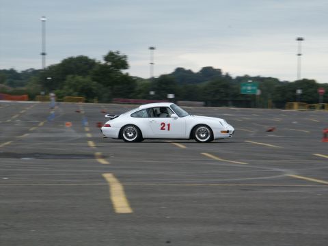 2001 Mercury Grand Marquis - White Porsche 911 with racing number 21 is seen on a track during an event.