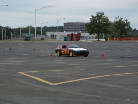 2001 Mercury Grand Marquis - A race-prepped Porsche 944 navigates a course marked by orange cones in an empty parking lot.