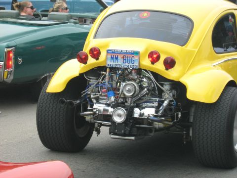 1988 Mercury Grand Marquis - A custom yellow Volkswagen Beetle displays its exposed engine and a 1968 license plate at a car show.