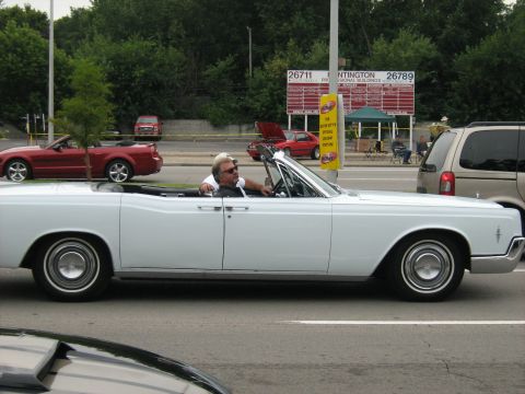 1988 Mercury Grand Marquis - Classic white convertible cruising down the road with passengers enjoying the ride.