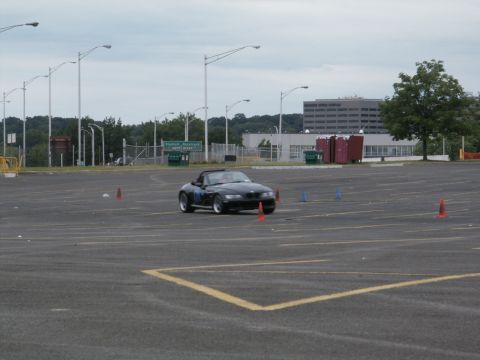 2001 Mercury Grand Marquis - A black convertible navigates a cone course in an empty parking lot under a cloudy sky.