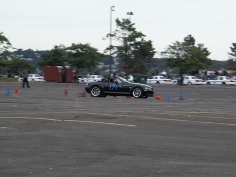 2001 Mercury Grand Marquis - A black convertible sports car with racing number 171 navigates a course marked by orange cones.