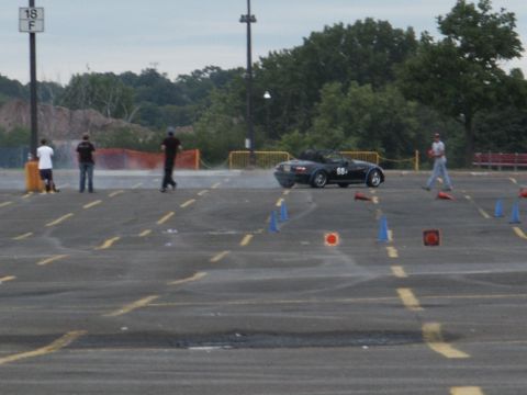 2001 Mercury Grand Marquis - A black convertible sports car navigates a course marked by cones during an event.