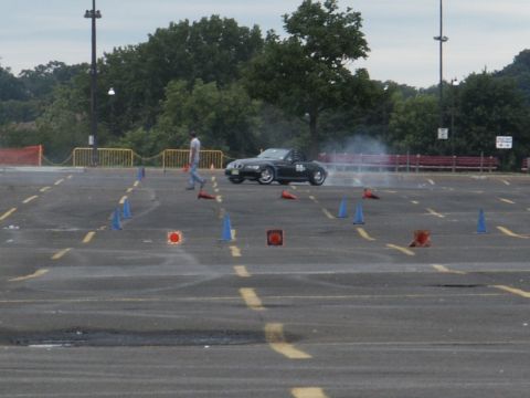 2001 Mercury Grand Marquis - A black convertible sports car is seen drifting in a parking lot during an event, with cones marking a course.