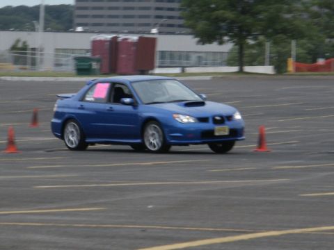 2001 Mercury Grand Marquis - A blue Subaru Impreza WRX is seen on an autocross course with orange cones marking the path.