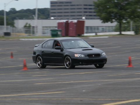 2001 Mercury Grand Marquis - A black Subaru Legacy GT navigates a course marked by orange cones.