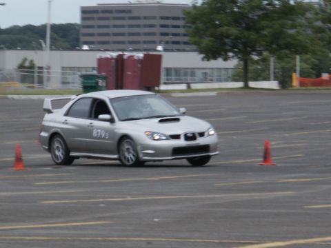 2001 Mercury Grand Marquis - Silver Subaru Impreza WRX STI navigates a course marked by orange cones, displaying the number 879s on its door.