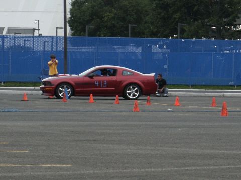 2001 Mercury Grand Marquis - A red coupe with racing numbers is positioned on a paved lot, surrounded by traffic cones.