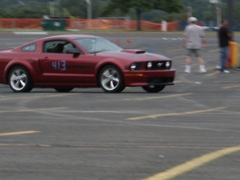 2001 Mercury Grand Marquis - Red Ford Mustang with blue number 413 on the door is seen on a paved track.