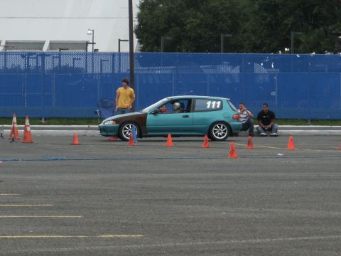 2001 Mercury Grand Marquis - A teal and brown hatchback, marked with the number 111, sits on an asphalt lot surrounded by orange cones.