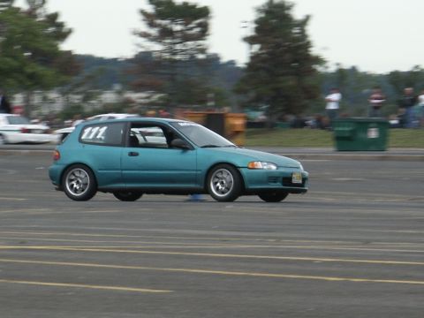 2001 Mercury Grand Marquis - Teal 1992 Honda Civic hatchback with racing number 111 on door, driving on asphalt track.