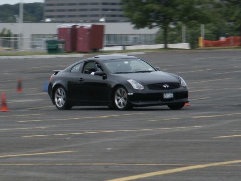 2001 Mercury Grand Marquis - Black Infiniti G35 coupe navigates a course marked by orange cones on a paved lot.