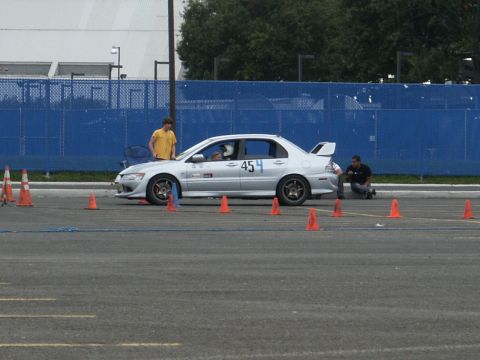 2001 Mercury Grand Marquis - A silver sedan with racing modifications is positioned on a paved surface marked with cones, suggesting a track event.