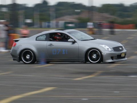 2001 Mercury Grand Marquis - Silver Infiniti G35 coupe with racing numbers on the door is seen on a track.
