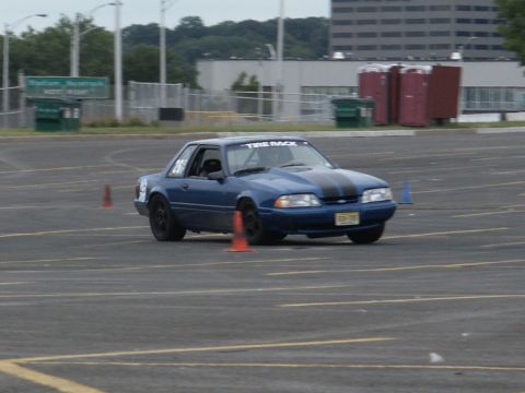 2001 Mercury Grand Marquis - Ford Mustang with "Tire Rack" banner seen on a track during an event.