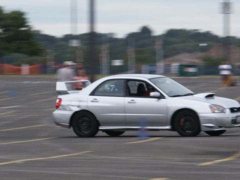2001 Mercury Grand Marquis - Silver Subaru Impreza WRX navigates an auto-cross course with cones visible.