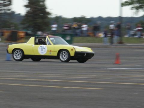 2001 Mercury Grand Marquis - A yellow Porsche 914 is seen on a race track, navigating around cones.